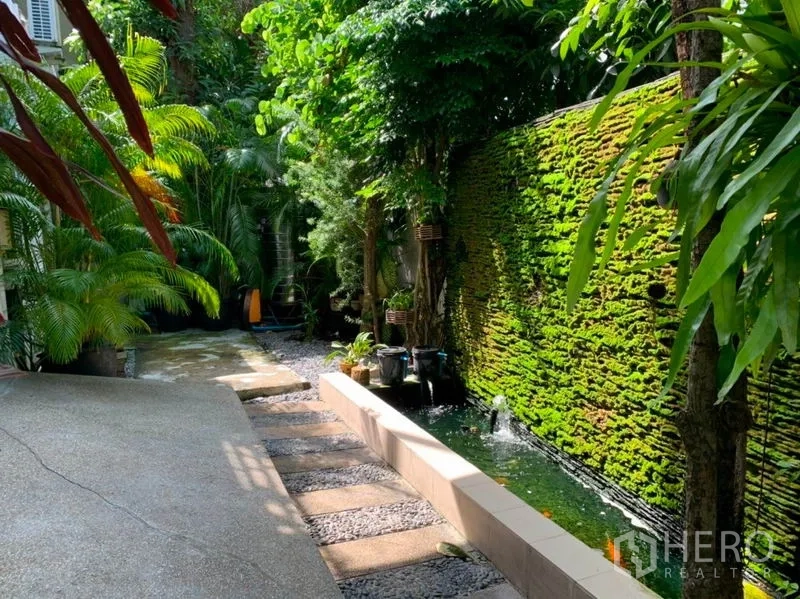 Detached House for sale in Suan Luang, Bangkok - Landscaped backyard featuring a mossy vertical wall, fish pond water feature and stepping stones.