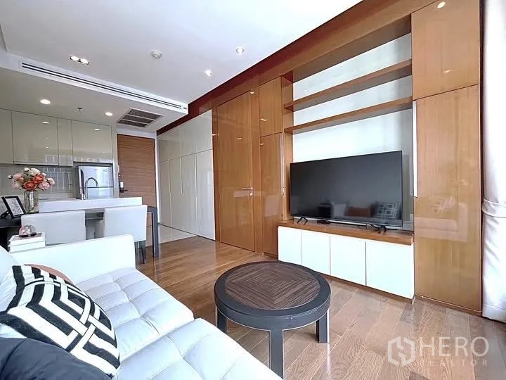 公寓 for rent in Khlong Toei, Bangkok - 开放式客厅，电视墙与木质柜体，吧台式餐区与木地板。