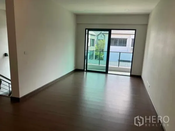 独立式住宅 出租在Khlong Sam Wa, Bangkok - 明亮房间，推拉玻璃门通向阳台，木地板。
