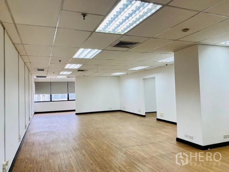 办公空间 出租或出售在Watthana, Bangkok - 明亮的长方形开放式办公室，白墙、格栅天花与城市景观。