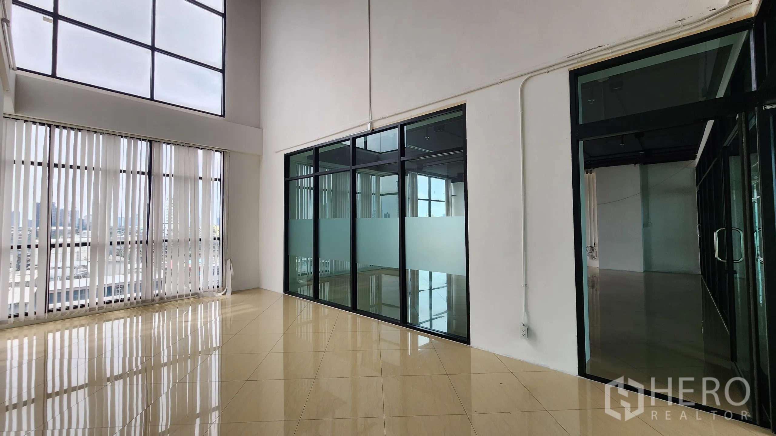 办公空间 出租在Yan Nawa, Bangkok - 明亮一隅，竖向百叶与黑框玻璃隔间相邻。
