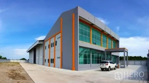 Factory for rent or sale in Bang Sao Thong, Samut Prakan - Modern two-story factory exterior with glass facade and driveway parking.