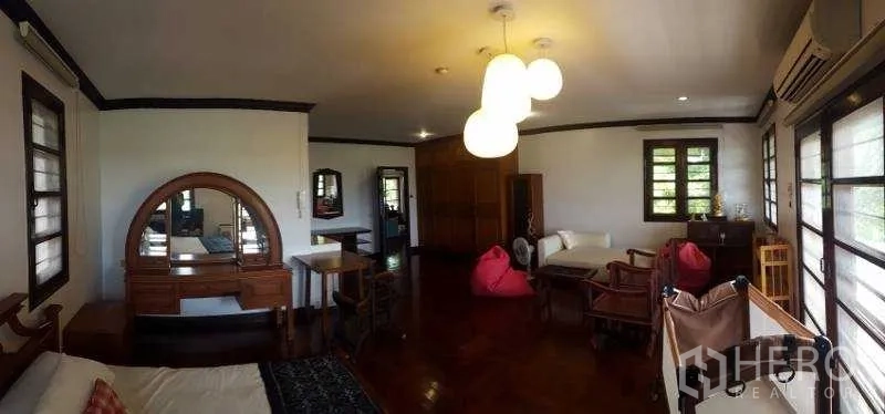 独立式住宅 出租在Bang Phli, Samut Prakan - 大卧室，亮面木地板、梳妆台与休闲区。