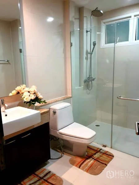 Apartment for rent - Fully tiled bathroom with glass shower enclosure, rain shower and vanity.