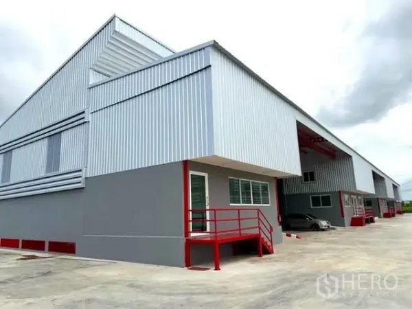 Warehouse for rent in Bang Bo, Samut Prakan - Corner view of the warehouse building with office door, windows, and large forecourt.
