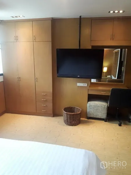 公寓 出租在Watthana, Bangkok - 卧室设定制衣柜、壁挂电视与书桌。