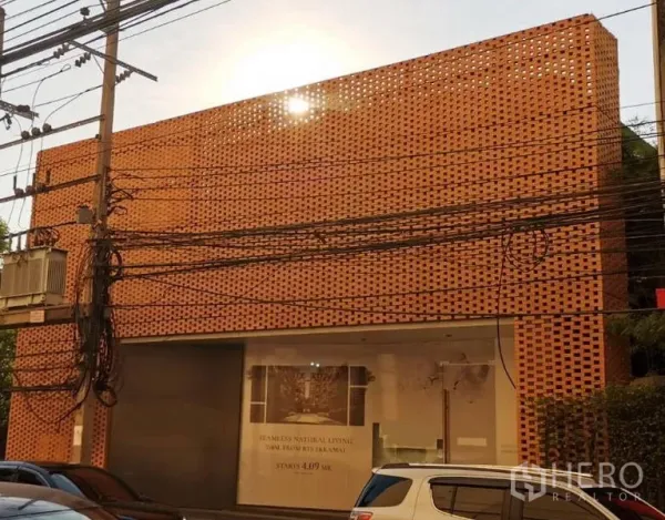 Retail Space for rent in Khlong Toei, Bangkok - Street view of a two-storey retail showroom featuring a terracotta perforated brick facade and large display window.