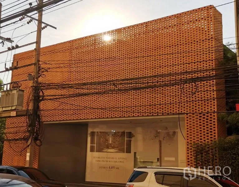Retail Space for rent in Khlong Toei, Bangkok - Street view of a two-storey retail showroom featuring a terracotta perforated brick facade and large display window.