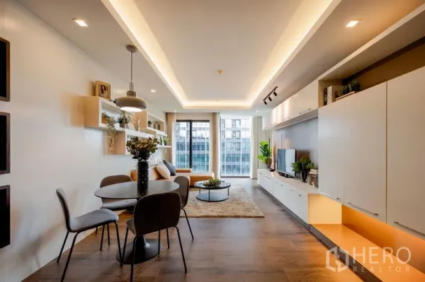 Condominium for sale in Khlong Toei, Bangkok - Another view of the dining and living room with cove lighting and balcony windows.