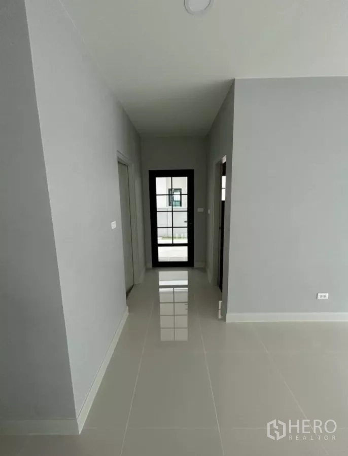 Detached House for rent in Bang Phli, Samut Prakan - Bright hallway with tiled floor leading to a glass door and rooms on both sides.