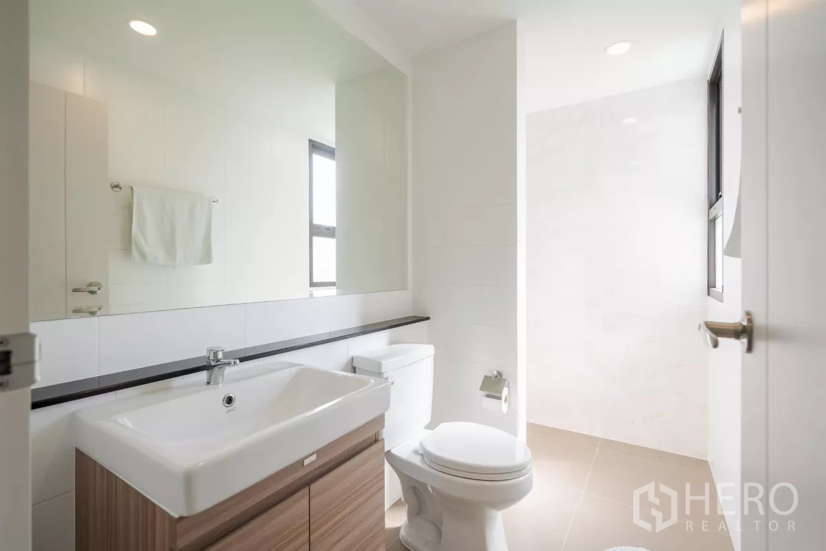 Detached House for sale in Saphan Sung, Bangkok - Guest bathroom with vanity, large mirror and shower area.