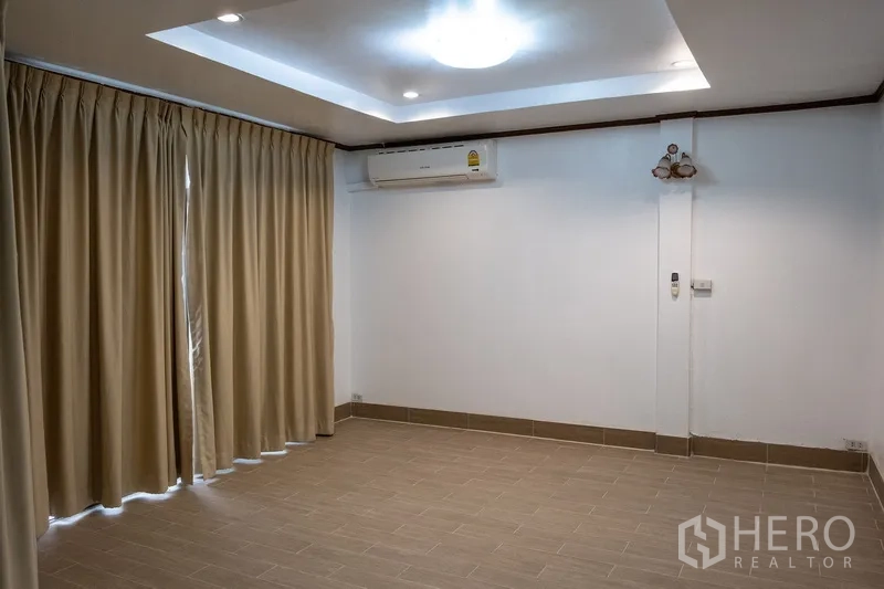 Home Office for rent in Khlong Toei, Bangkok - Large bedroom with recessed ceiling, air conditioner and full-length curtains.