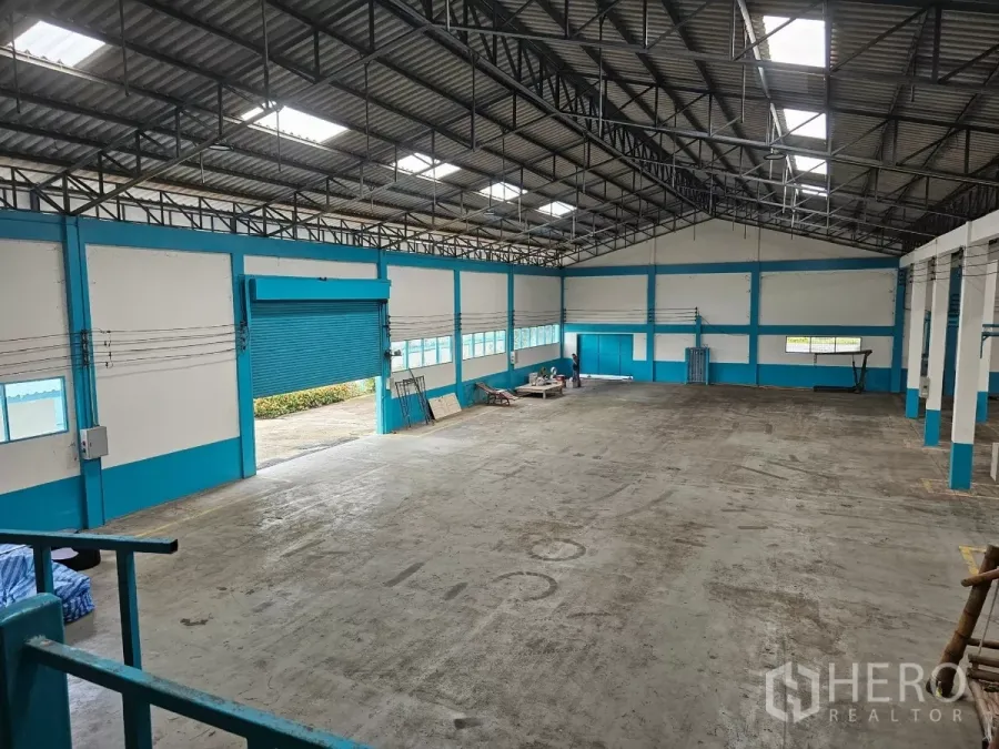 โรงงาน ให้เช่าหรือขายในMueang Rayong, Rayong - ภายในโรงงานกว้าง เพดานโครงเหล็กสูง มีแผ่นรับแสง พื้นคอนกรีตแข็งแรง และประตูม้วนสีน้ำเงินบานใหญ่
