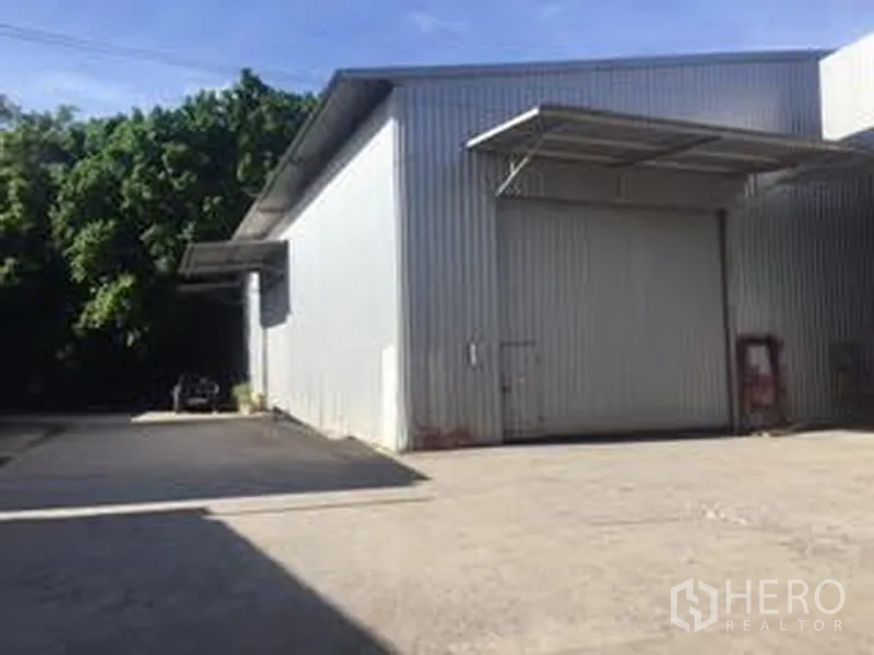 Warehouse for rent in Sai Mai, Bangkok - Metal-clad warehouse exterior with large sliding door, loading canopy and wide concrete yard in Sai Mai, Bangkok.