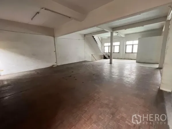 店屋 出租在Watthana, Bangkok - 宽阔开放大厅，拼木地板、大窗与楼梯连接各层。