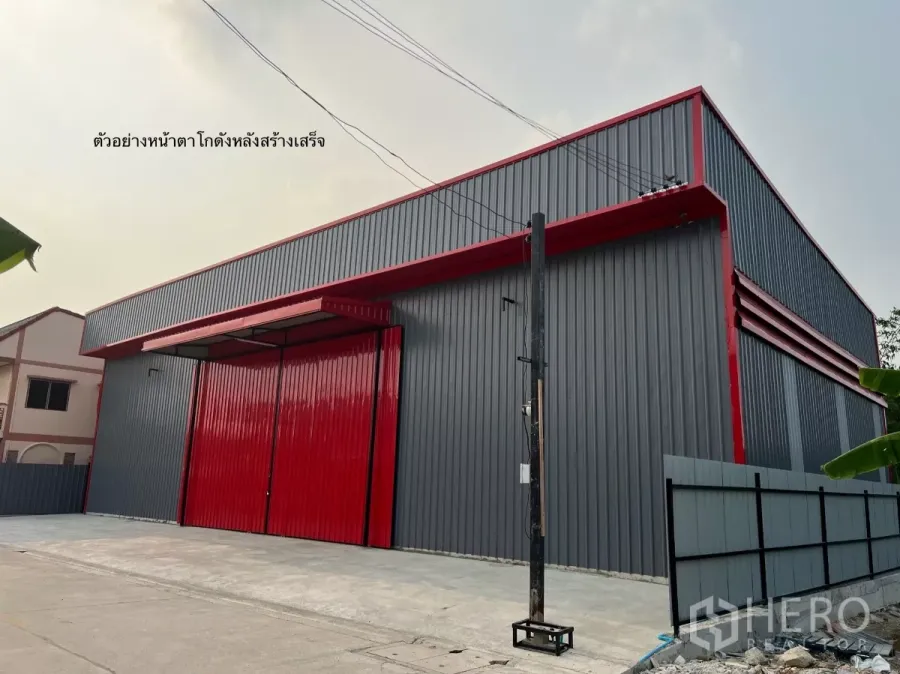 Warehouse for rent in Bang Kapi, Bangkok - Modern steel warehouse exterior with red sliding doors and a wide concrete forecourt in Bang Kapi.