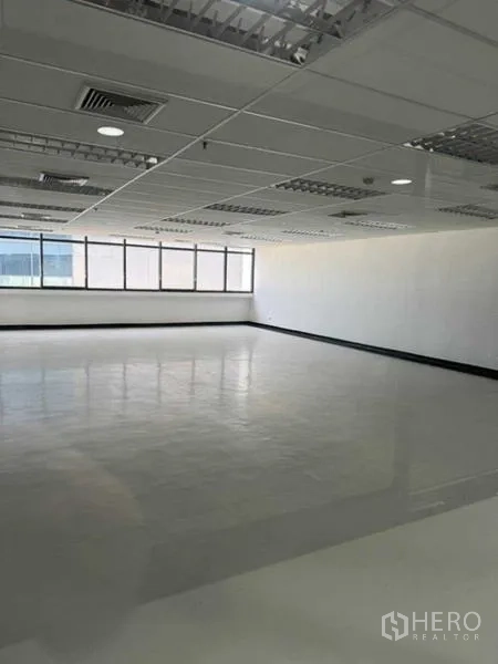 办公空间 出租或出售在Phaya Thai, Bangkok - 开放工作区，整排窗户、白色墙面与带空调出风口的吊顶。