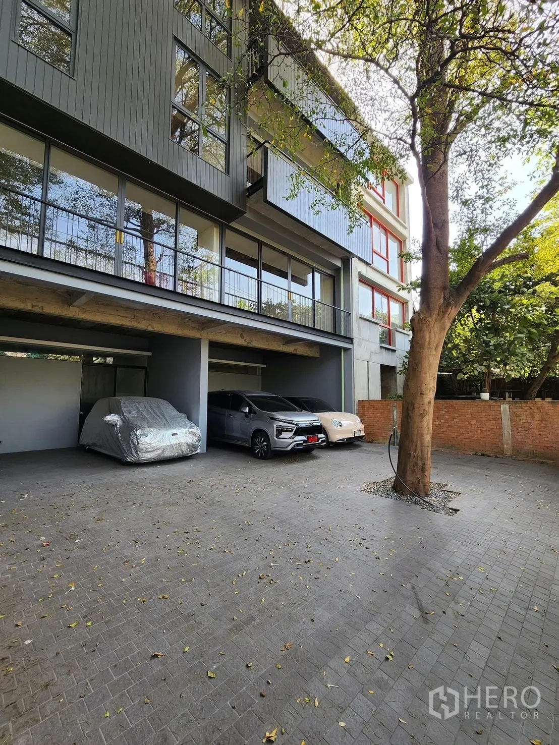 Home Office for rent in Chatuchak, Bangkok - Building exterior with covered parking bays and modern glass facade.