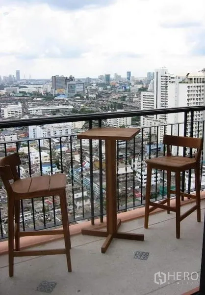 คอนโด ขายในKhlong Toei, Bangkok - ระเบียงส่วนตัวพร้อมชุดโต๊ะบาร์ไม้ มองเห็นวิวสกายไลน์กรุงเทพฯ
