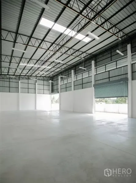 工厂 出租或出售在Nakhon Pathom - 仓库内部，高挑屋顶、采光带、钢桁架与抛光混凝土地面。