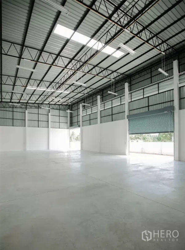 工厂 出租或出售在Nakhon Pathom - 仓库内部，高挑屋顶、采光带、钢桁架与抛光混凝土地面。