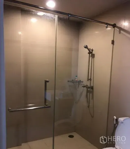 公寓 出租在Khlong San, Bangkok - 玻璃隔间步入式淋浴，手持花洒与瓷砖墙面。