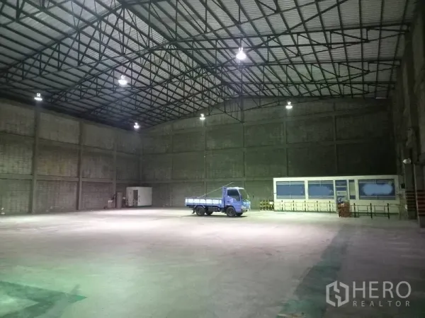 Warehouse for rent in Mueang Pathum Thani, Pathum Thani - Spacious warehouse interior with high ceiling, steel truss roof and bright overhead lighting.