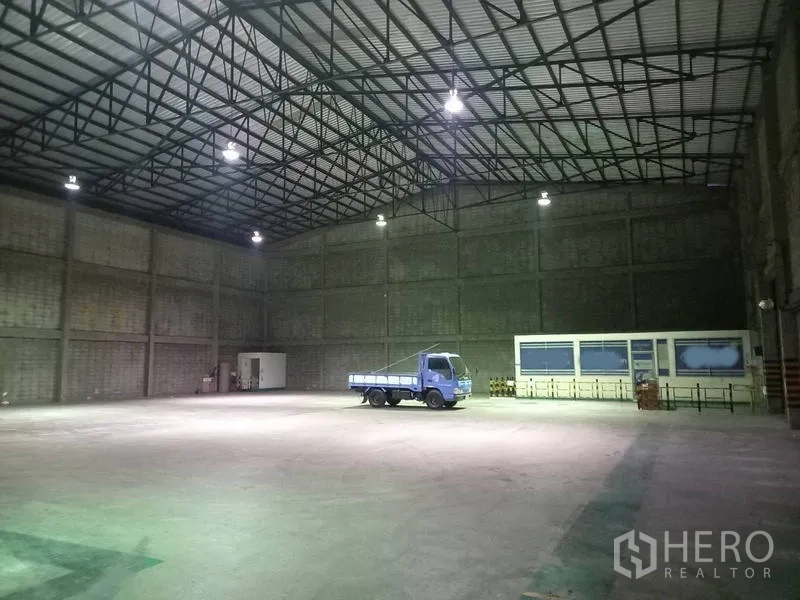 Warehouse for rent in Mueang Pathum Thani, Pathum Thani - Spacious warehouse interior with high ceiling, steel truss roof and bright overhead lighting.