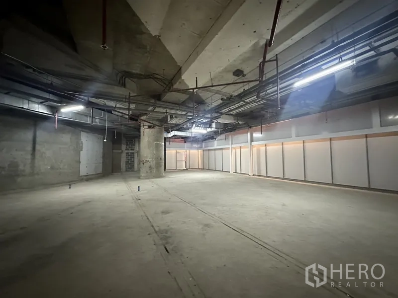 Retail Space for rent - Open-plan retail shell with high ceiling, exposed ducts and concrete floor ready for tenant fit-out.