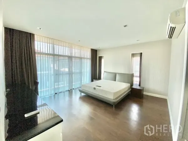 独立式住宅 出租在Prawet, Bangkok - 主卧宽敞，木地板，落地窗与空调