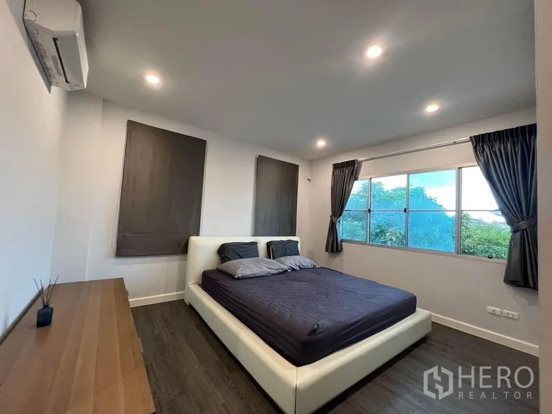 Detached House for sale in Bang Kruai, Nonthaburi - Master bedroom with king bed, wide windows, garden view and air conditioner.