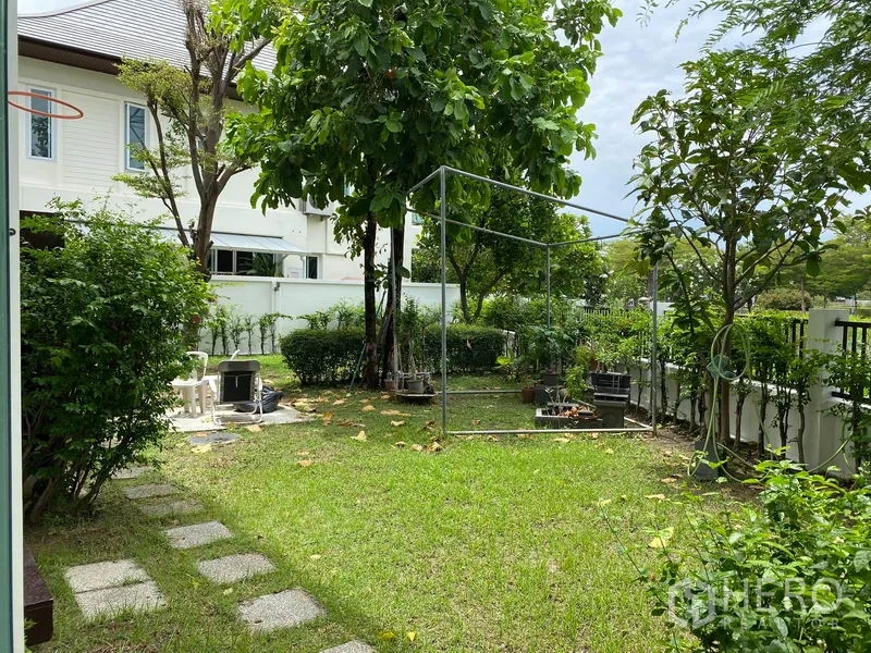 独立式住宅 出租在Prawet, Bangkok - 私家庭院一角，草坪、成树与白色围栏营造清新绿意。