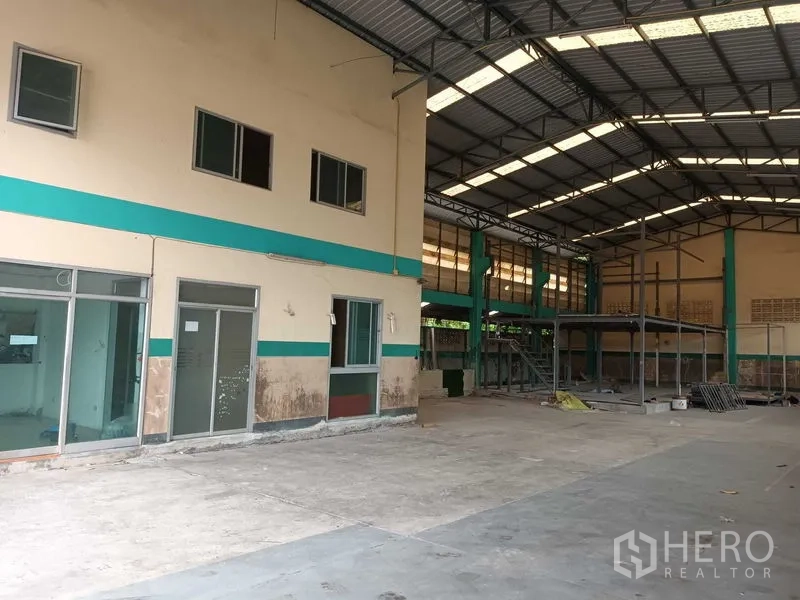 Warehouse for rent in Phasi Charoen, Bangkok - Spacious warehouse interior with high steel roof, office block and mezzanine frame.