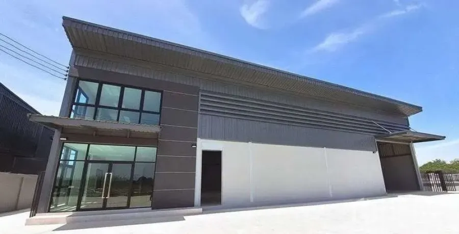 Factory for rent or sale in Bang Bo, Samut Prakan - New-build factory exterior with glass-front office, wide driveway and a sheltered loading bay under a metal roof in Bang Bo, Samut Prakan.