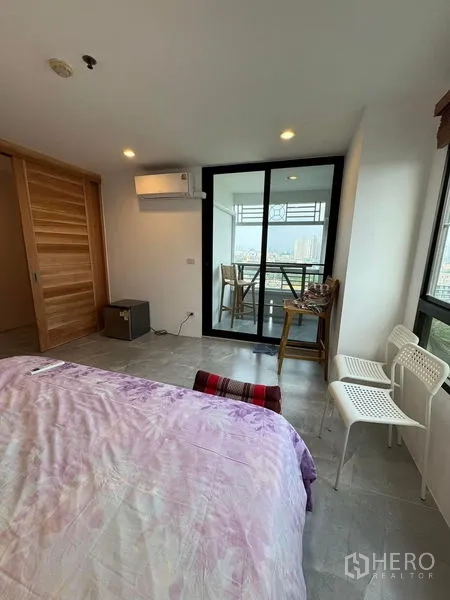 Condominium for rent or sale - Bedroom with sliding doors to a balcony, small table set, and city views.