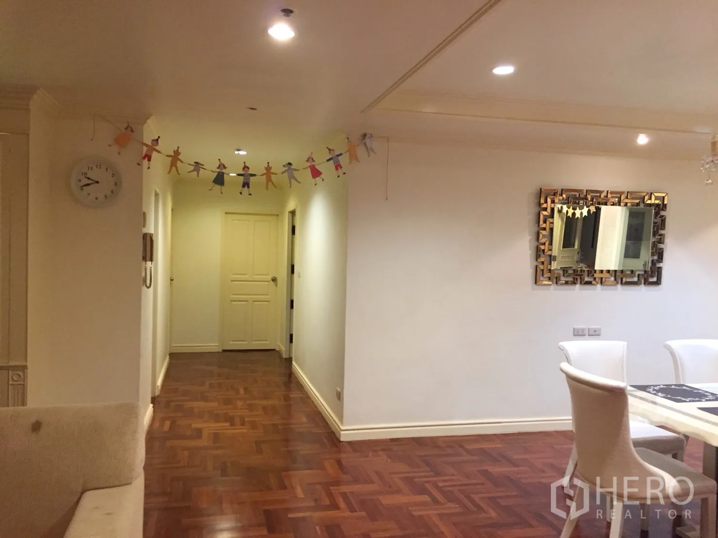 公寓 出租在Watthana, Bangkok - 通往卧室的走廊，木地板、嵌灯天花和装饰镜。