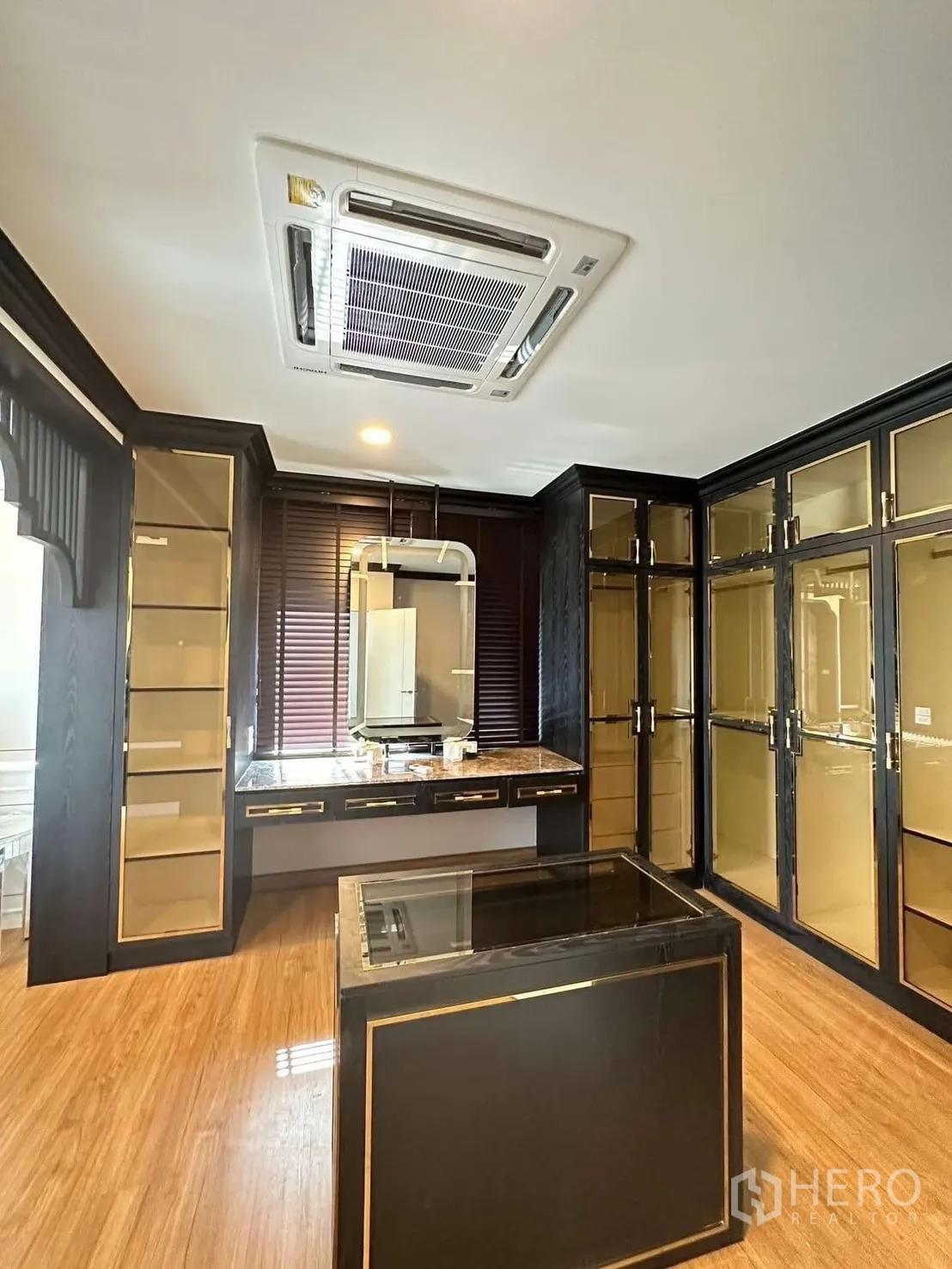 独栋房屋 for rent in Bang Phli, Samut Prakan - 衣帽间配中岛与梳妆台，周围为深色玻璃柜。