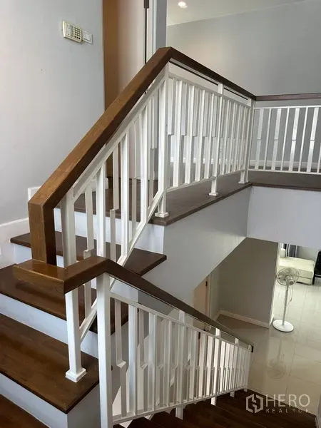 Detached House for rent in Lam Luk Ka, Pathum Thani - Interior staircase with wooden treads and white balustrade.