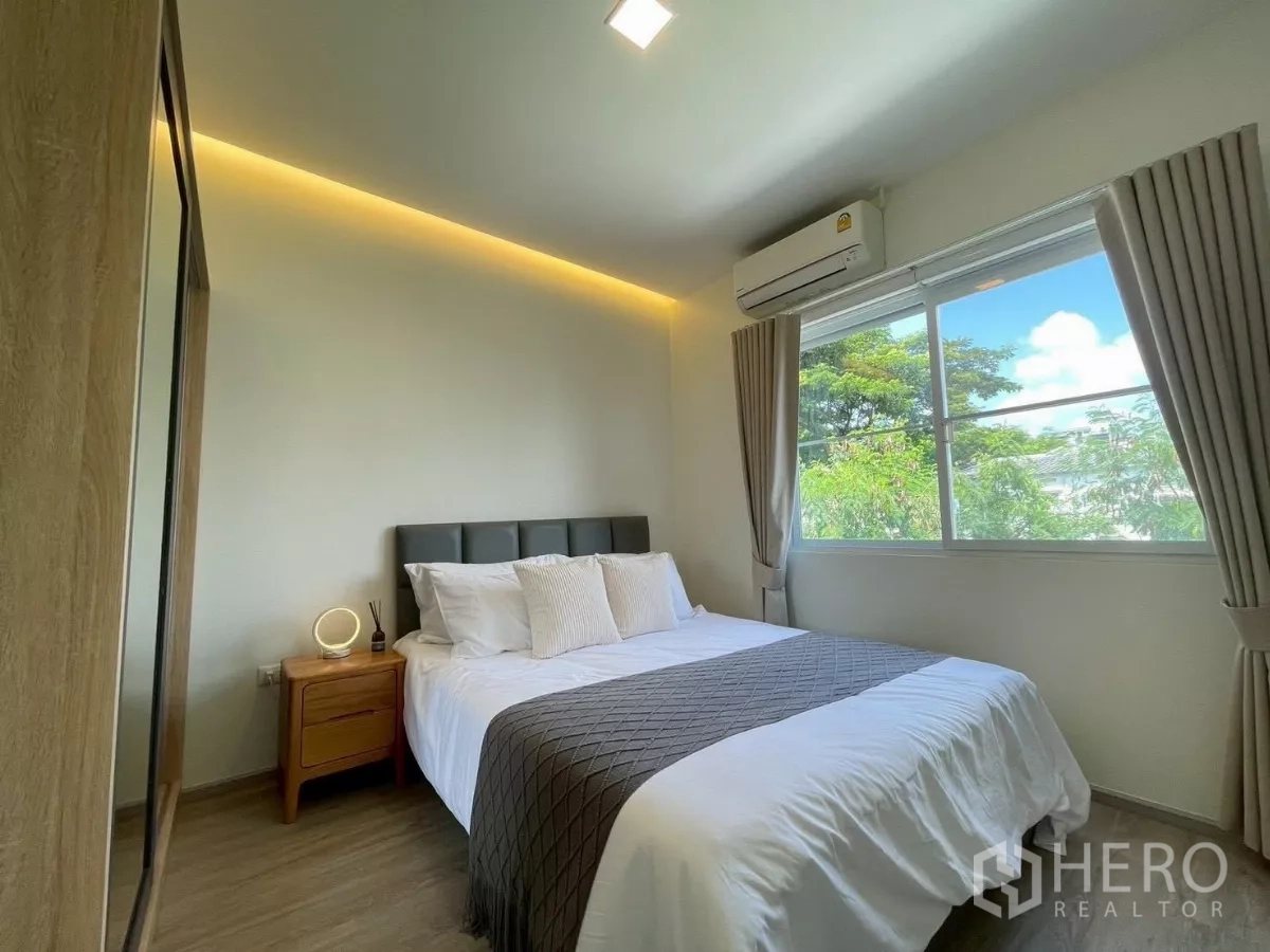 联排别墅 出租在Prawet, Bangkok - 客卧配双人床、床头柜与宽窗。
