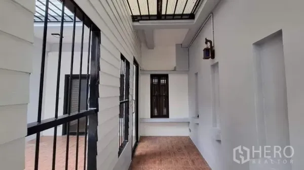 联排别墅 出租或出售在Chatuchak, Bangkok - 带顶侧露台走廊，白墙与黑色防护栏
