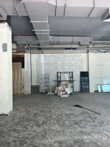 零售空间 出租在Khlong Toei, Bangkok - 毛坯商铺，层高充足，现场有梯子与装修材料，开放式布局便于多种业态。