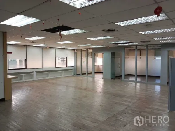 办公空间 出租在Watthana, Bangkok - 开放式办公室，木纹地板、吊顶、荧光灯与玻璃隔断会议室。