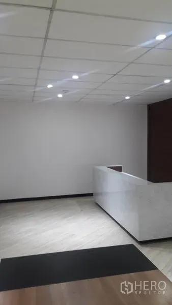 Office Space for rent in Huai Khwang, Bangkok - Bright reception area with drop ceiling lights and a white stone counter in an office space.