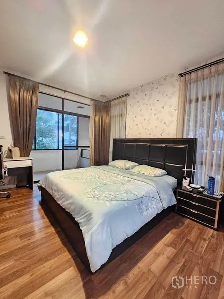 บ้าน ขายในPrawet, Bangkok - ห้องนอนใหญ่ พื้นไม้ เตียงขนาดใหญ่ หน้าต่างระเบียงและผ้าม่านโปร่ง