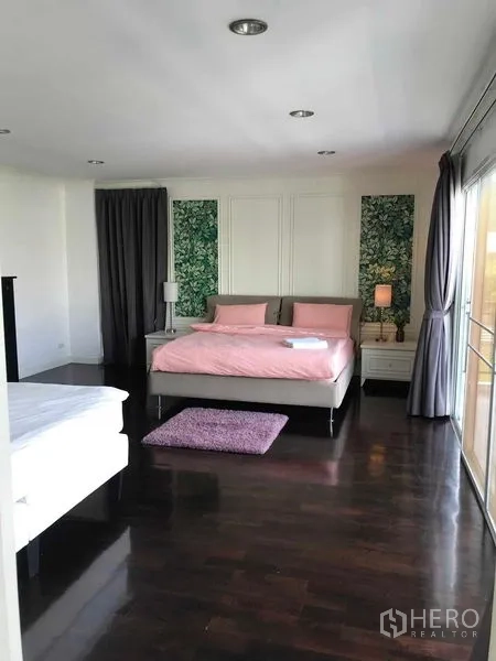 Detached House for sale in Wang Thonglang, Bangkok - Large bedroom with pink bedding, dark wood flooring and sliding glass doors