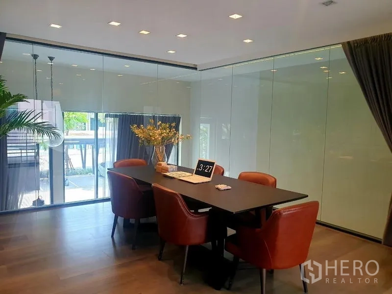 Home Office for rent - Glass‑walled conference room with black table and leather chairs.