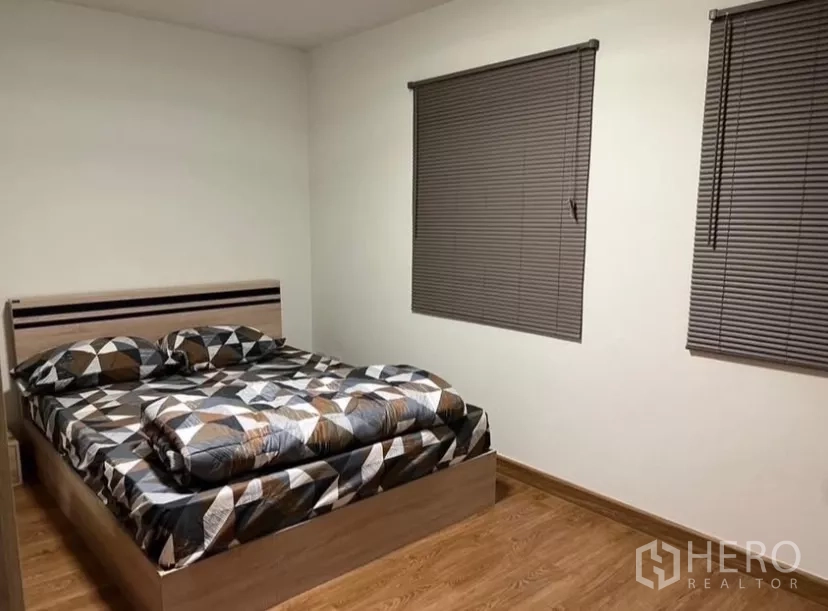 Detached House for rent or sale in Prawet, Bangkok - Second bedroom with wood floors, blinds and a queen bed.