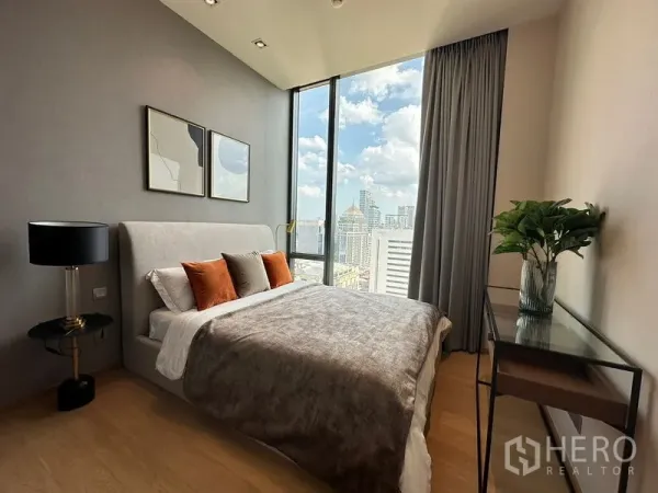 公寓 出租在Pathum Wan, Bangkok - 卧室配软包床，落地窗外是城市天际线景观。