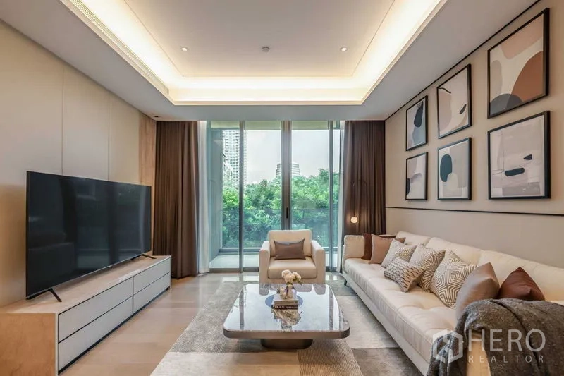 公寓 出售在Pathum Wan, Bangkok - 客厅通向阳台，可眺望绿意与城市天际线。