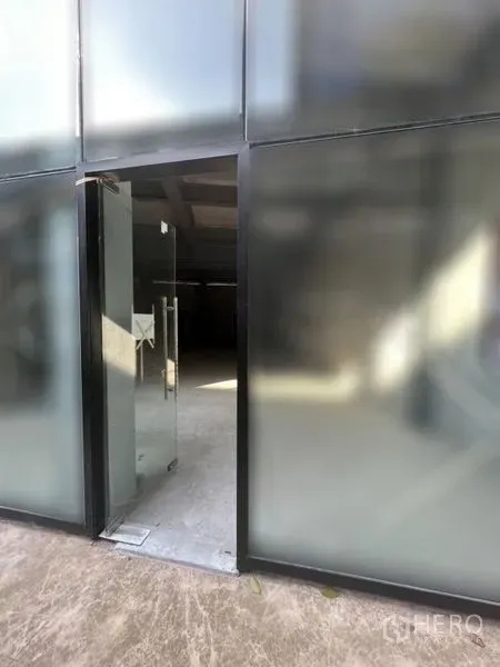 零售空间 出租 - 地面层零售商铺的磨砂玻璃立面，带开启的玻璃门。